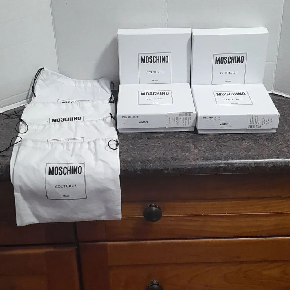 4 Moschino Deluxe Boxes, 4 Deluxe Dust Bags, and 1 and one Enclosure.